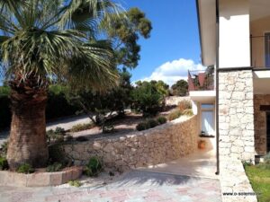 Villa Smeralda: Palme vor dem Haus und Gartenmauer