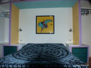 Doppelbett unter einem bunten Wandbild