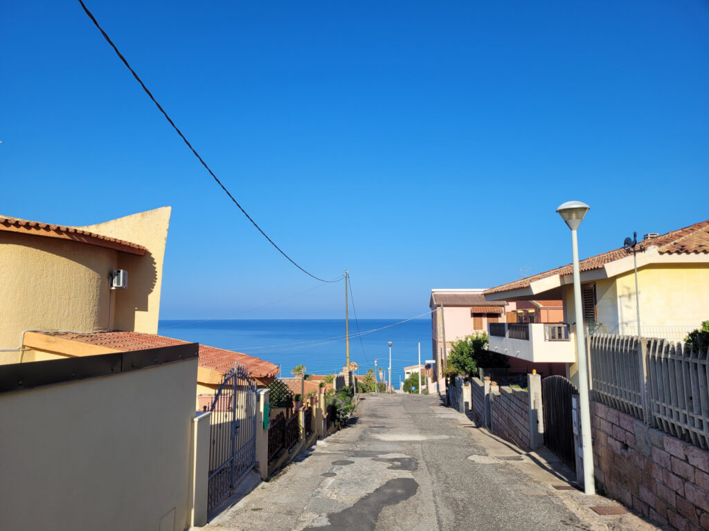 Straße zwischen Häusern hinunter zum Meer Straße zwischen Häusern hinunter zum Meer