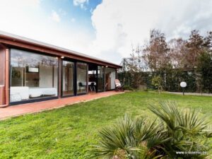 Casa Laura, Chia: Haus mit großen Glasfenstern und Rasen