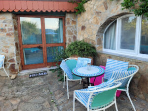 Sa Petra Ruja: Terrasse mit Gartenmöbeln vor der Natursteinfassade