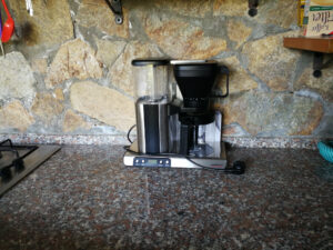 Kaffeemaschine in der Außenküche vor einer Natursteinwand