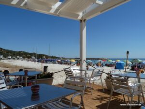 Strandbar mit Tischen unter einer Pergola