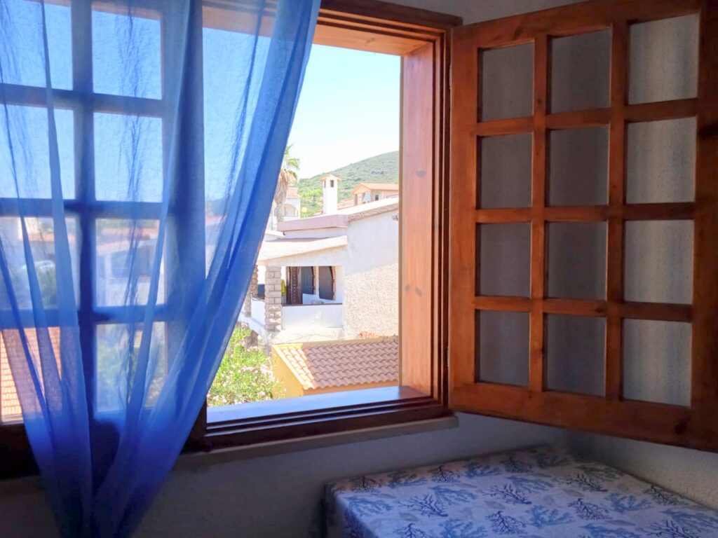 Agrustos Mare, Budoni: Fenster mit blauen Vorhängen und Blick ins Freie Agrustos Mare, Budoni: Fenster mit blauen Vorhängen und Blick ins Freie