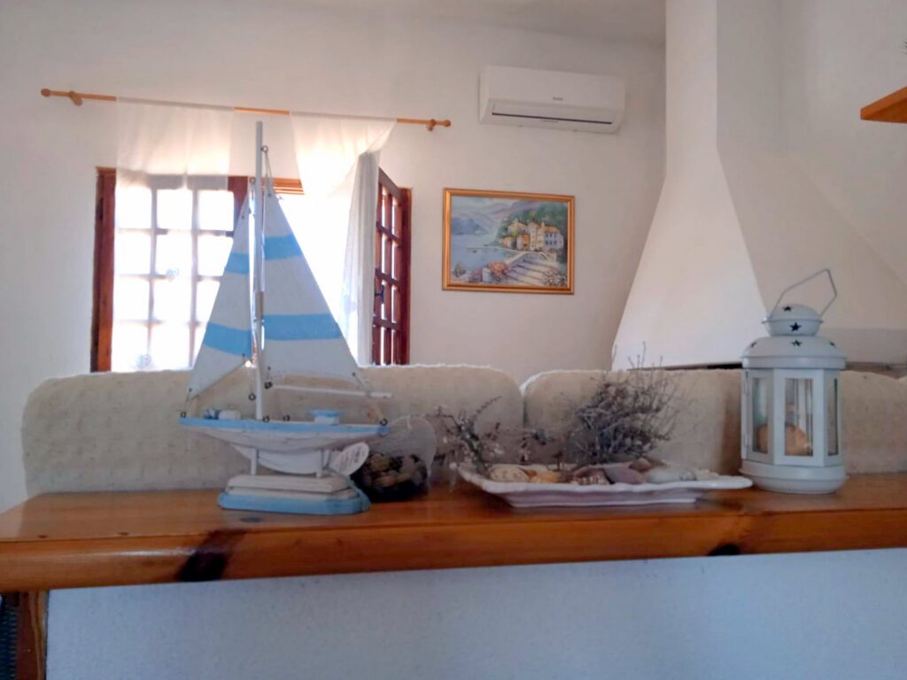Agrustos Mare, Budoni: Wohnraum mit Sofa und Kamin Agrustos Mare, Budoni: Wohnraum mit Sofa und Kamin