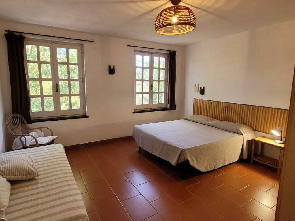 Dreierschlafzimmer-Villa Magico-019 Villa Domosdei: Dreibettzimmer mit Holzboden und zwei Fenstern